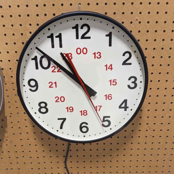 An indoor clock with a 12/24 hour dial, suitable for use in commercial settings