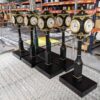 A group of small miniature post clocks in various stages of production in a factory setting."