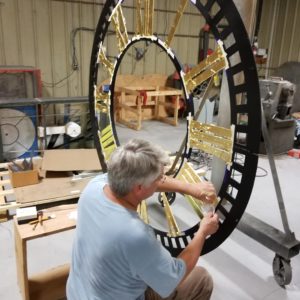 Gold leaf applied on a cast iron tower clock dial in a tower clock manufacturing facility