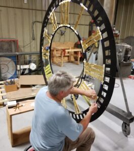 Gold leaf applied on a cast iron clock dial in tower clock manufacturer's facility.