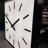 A large square tower clock with a 72 inch diameter being manufactured in a factory