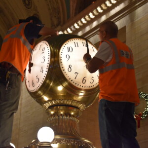 Adjusting clock hands to 12 o'clock on the Globe Clock at Grand Central Terminal.